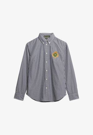 Langdurige met lange mouwen en knopen shirt met zwart-witte verticale strepen en een gouden geborduurd wapen op de linkerkant van de borst.