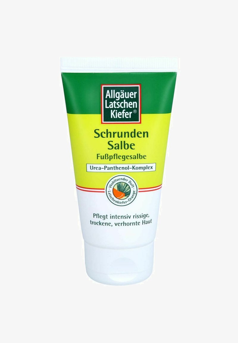 Fußpflegesalbe in einer grünen und gelben Tube zum Drücken, beschriftet mit "Schrunden Salbe", mit einem roten Logo auf weißem Grund.