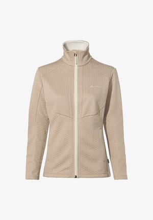 Hellbeige Reißverschlussjacke mit einem strukturierten Wabenmuster, hohem Kragen und weißen Reißverschluss. Mit Logo auf der linken Brust und einem grünen Akzentanhänger.