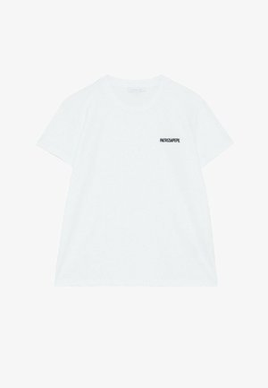 T-shirt bianca in cotone con maniche corte, scollatura rotonda e un logo nero sul lato sinistro del petto. Tessuto morbido e vestibilità casual.