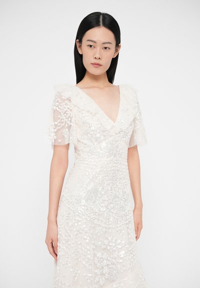 Rochie albă cu mâneci bufante transparente, decolteu în V și modele intricate de mărgeluțe. Material texturat cu detalii stratificate și talie mulată.