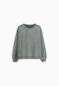 Sweat-shirt gris surdimensionné en tissu doux avec un col rond, des poignets et un ourlet côtelés. Texture lisse, sans motifs visibles ni détails métalliques.