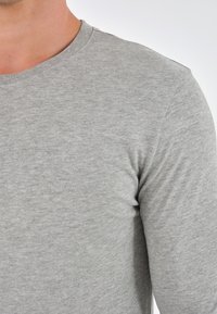 Gray long-sleeve T-shirt made of soft cotton fabric, featuring a crew neckline and a smooth texture with minimal stitching details.