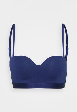 Tengerészkék melltartó sima textúrával, kontúros kosarakkal, állítható pántokkal, és egy selyemszalaggal, amelyen elöl dombornyomott logó található.