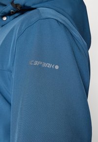 Blue jacket with a smooth, slightly textured fabric. The left sleeve features a light gray logo reading "ICEPEAK" in a modern font.