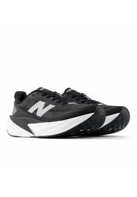 Des chaussures de sport noires présentent une tige en maille avec des accents gris, un bout arrondi, une épaisse semelle intermédiaire blanche et une semelle extérieure noire texturée.