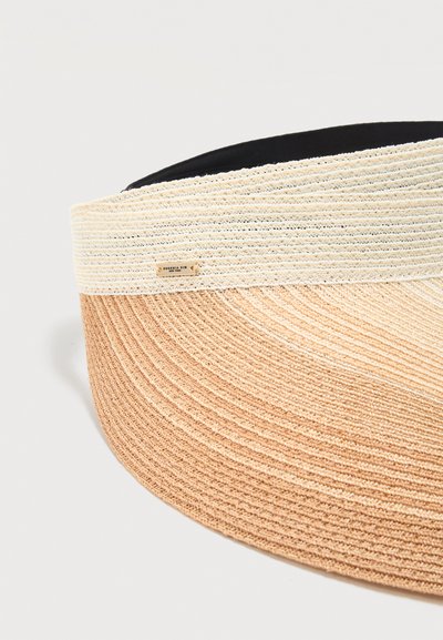 Μπεζ και ανοιχτό καφέ πλεκτό φαρδύ καπέλο με μαύρη εσωτερική επένδυση και μικρή ορθογώνια ετικέτα της μάρκας στο πλάι.