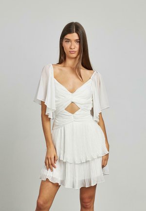 Vestido blanco con mangas cortas y acampanadas, textura plisada, un corte en forma de llave en la cintura y una falda de capas. Tejido suave y ligero.