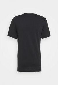 Camiseta de algodón negra, de manga corta, cuello redondo, textura suave, diseño liso, sin logotipos ni patrones visibles. Vista trasera únicamente.