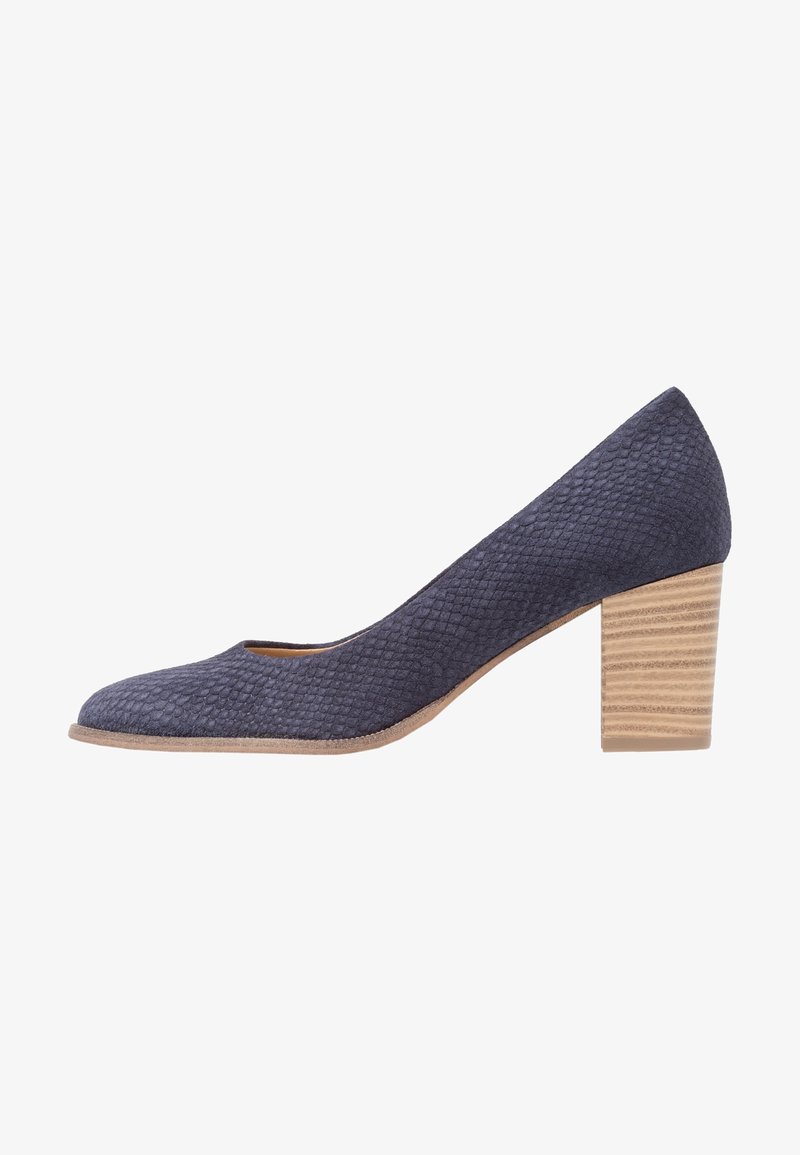 Escarpin en daim texturé bleu marine avec un bout arrondi et un talon bloc en bois empilé, présenté de profil sur un fond blanc.