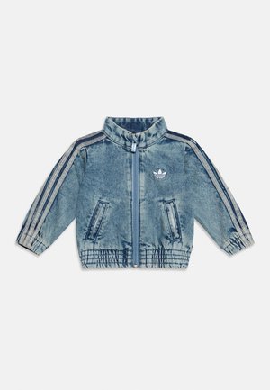 Veste zippée en denim bleu avec col montant, deux poches avant, poignets et ourlet élastiqués, et trois bandes bleues sur chaque manche.