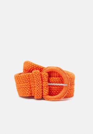 Heldere oranje gevlochten stoffen riem met een bedekte ronde gesp en een zilveren tong, opgerold op een witte achtergrond.