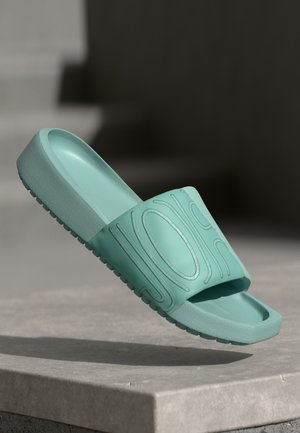 Aqua slide sandaal van rubber met een brede band met reliëf golfpatronen en een gestructureerde zool voor grip.