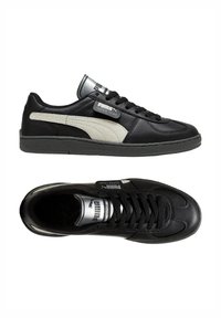 Sneakers nere in pelle con finitura testurizzata. Presentano un logo bianco sul lato, design con lacci e una linguetta imbottita. Suola in gomma, accenti minimalisti.