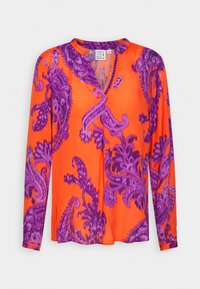 Blusa a maniche lunghe di un brillante arancione con motivo paisley viola, caratterizzata da una scollatura a V e dettagli ricamati lungo il bordo.