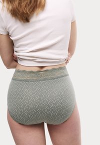 Olivegrön hipsterunderkläder i bomull med vita prickar, som har en spetsmidja och en mjuk textur.