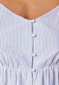 Lehk dress s knoflíky a proužky, který má modro-bílé vertikální pruhy, véčkový výstřih a řasený pas.