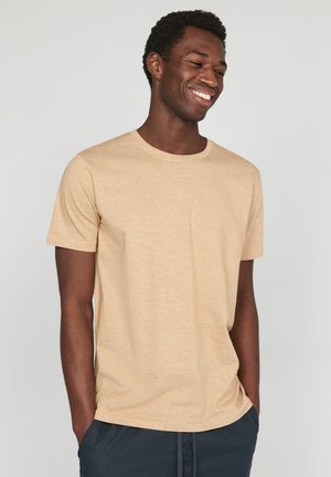 Kurzärmliges T-Shirt mit Rundhalsausschnitt in hellem Beige, aus strukturiertem Baumwollstoff mit einem subtilen, welligen Muster. Lässig geschnitten.