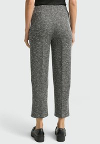 Zwart-witte geruite cropped broek met een textuurstof en een rechte snit, gecombineerd met zwarte schoenen.