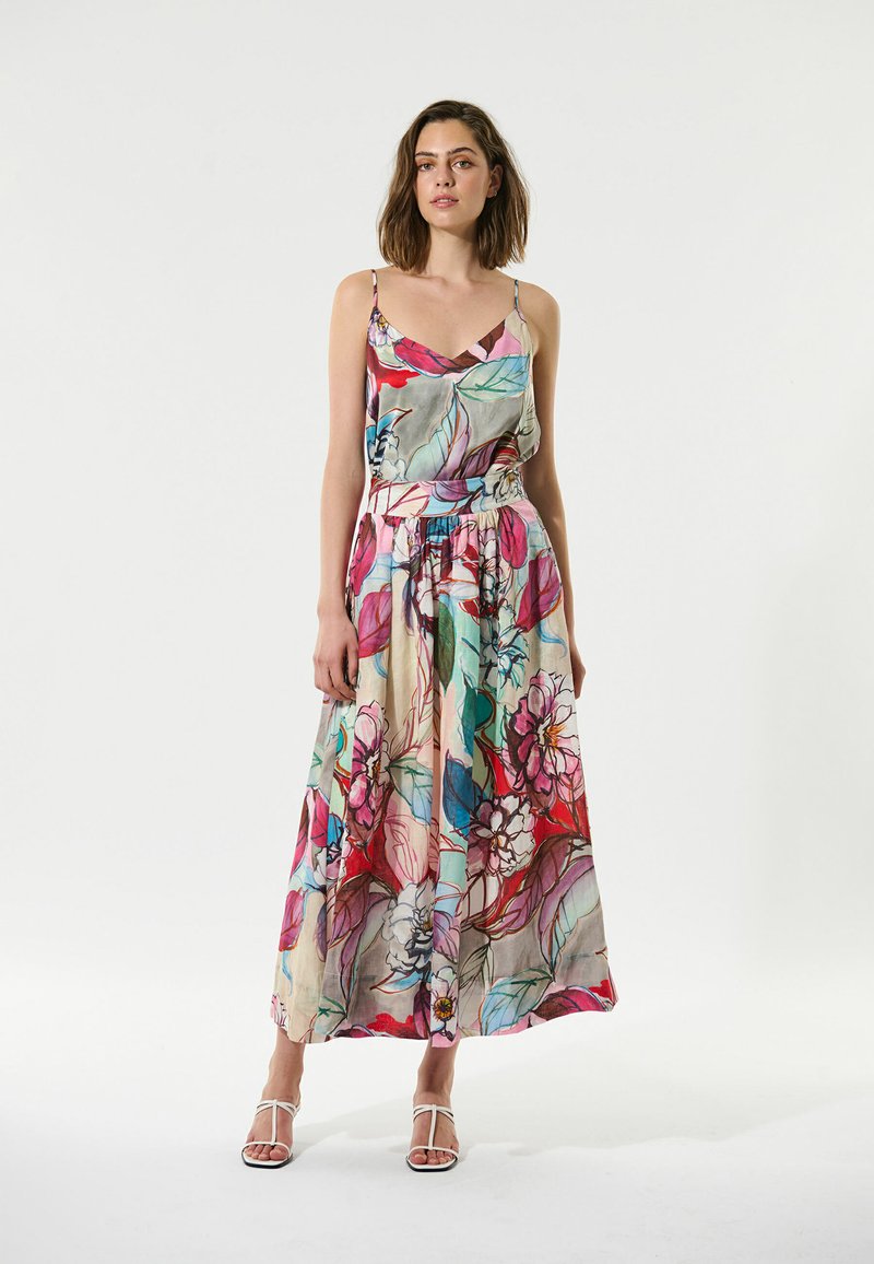 Maxi-jurk met bloemenprint, een V-hals en verstelbare spaghettibandjes. Beschikt over kleurrijke bladeren en bloemenpatronen op een lichtgewicht stof.
