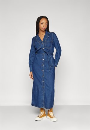Denim maxikjole med kragehals, lange ermer, frontknapper og belte i midjen. Har to brystlommer og rett snitt.