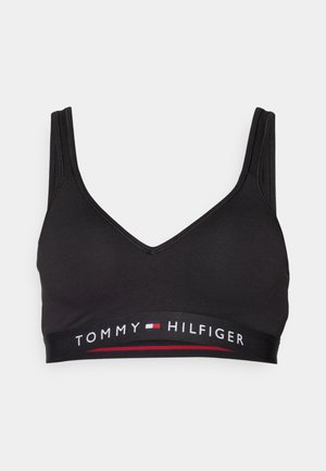 Schwarzer Sport-BH mit V-Ausschnitt-Design. Verfügt über verstellbare Träger und ein elastisches Band mit der Marke, das "TOMMY HILFIGER" in weißen und roten Buchstaben trägt.