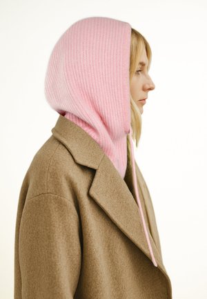 Cappotto di lana marrone con cappuccio spesso in maglia rosa a coste. Il cappuccio è dotato di coulisse e ha una texture morbida, offrendo calore e copertura.