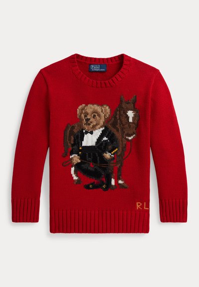 Roter Strickpullover mit einem Teddybär in einem schwarzen Smoking, der die Zügel hält, neben einem braunen Pferd stehend, mit RL-Initialen am Saum.