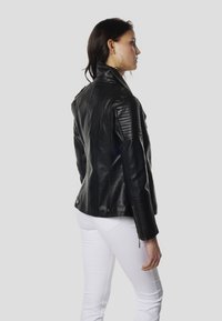 Čierna kožená motocyklová bunda s vystuženými plecami a prešívanými detailmi. Má priliehavý strih a zipsové manžety.