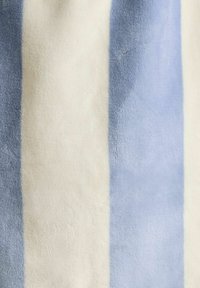 Pehmea rätik, millel on vertikaalsed triibud vahelduvates helesinistes ja valgetes värvides.