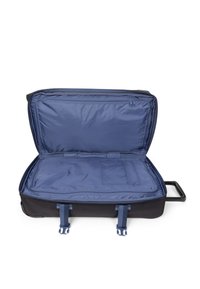 Valigia nera con ruote, dotata di un ampio interno blu, con cinghie di stivaggio e un compartimento con zip. Tessuto resistente con una maniglia robusta.