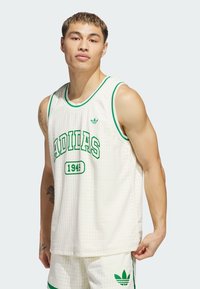 White mesh basketball jersey with green accents, featuring bold "ADIDAS" text and year "1949" on the front. Rounded neckline, sleeveless design.