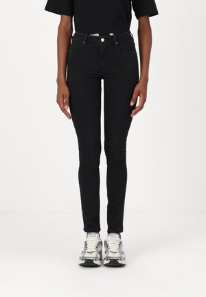 Zwarte skinny jeans gemaakt van denim met een hoge taille. Kenmerken zijn vijf zakken, zilverkleurige accessoires en een gladde textuur.
