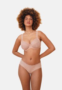 Lace bra and matching panties in light beige, featuring scalloped edges, floral patterns, and delicate detailing at the center.