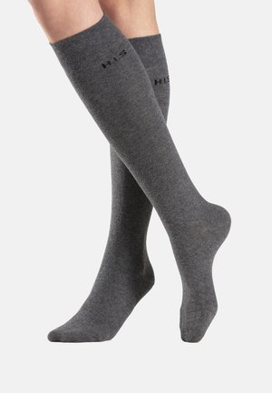 Graue knielange Socken aus weichem Material, mit einem gerippten Muster und einem Logodetail nahe der Oberkante, sowie einer glatten Oberfläche am Fuß.