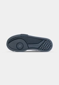 Sole in gomma con un motivo testurizzato, caratterizzata da un accento circolare, colore grigio e design ergonomico per una presa migliore.