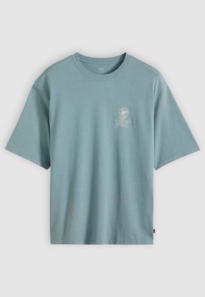 Ανοιχτό μπλε βαμβακερό t-shirt με στρογγυλή λαιμόκοψη και κοντά μανίκια. Διαθέτει μικρό λευκό λουλουδάτο σχέδιο στο αριστερό μέρος του στήθους.