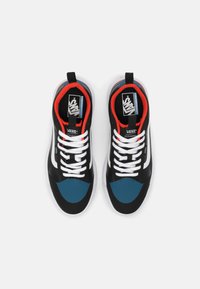 Chaussures de sport noires et bleues avec une tige en mesh, des lacets blancs, des bandes latérales emblématiques et des accents rouges sur le col et la semelle intérieure.