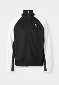 Crna i bijela Nike Air zip-up jakna s visokim ovratnikom, crnim prednjim dijelom i bijelim rukavima, prikazana na jednobojnoj pozadini.