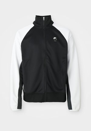 Fekete-fehér Nike Air zipzáras dzseki magas gallérral, fekete előlappal és fehér ujjal, sima háttér előtt kiállítva.
