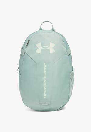 Mochila de un suave color verde menta, con una textura lisa, que presenta el logo de Under Armour, bolsillos laterales y correas ajustables.