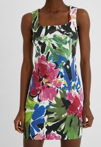 Mouwloze bloemenjurk met brede bandjes, versierd met grote rozen, blauwe, groene en zwarte penseelstreekachtige bloem- en bladvormen.