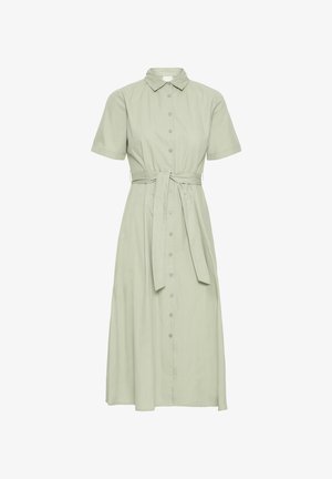 Jasnozielona sukienka koszulowa z krótkim rękawem, kołnierzykiem, zapięciem na guziki i paskiem w talii. Zwiewny materiał sięga do połowy łydki.