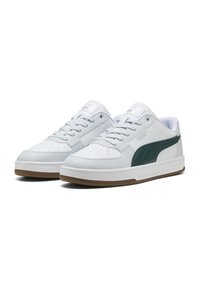 Zapatillas de cuero blanco con acentos verdes, punta redonda, detalles perforados y suela de goma. Presentan cordones planos y el logo de Puma en la lengüeta.