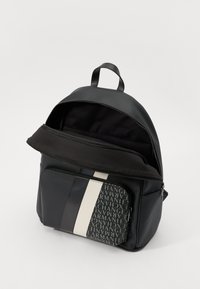 Black leather backpack with a front zip pocket featuring a gray patterned overlay. Main compartment with a zip closure and canvas lining.