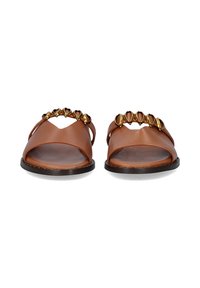 Sandalias de cuero marrón con correas anchas y un acento decorativo de cuentas doradas en la parte superior, con una suela plana negra.