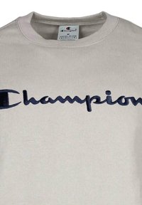 Sudadera gris de mezcla de algodón, con un gran logotipo de "Champion" en azul marino bordado en la parte frontal. Cuello y puños acanalados.