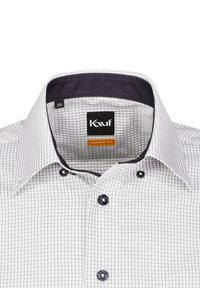 Camicia a scacchi bianca con bottoni neri e una chiusura del colletto di un blu navy scuro. Presenta un'etichetta di taglia e un'etichetta del marchio all'interno del colletto.