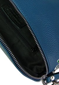 Blauwe leren tas met een gestructureerde afwerking, voorzien van een ritsluiting en een zwarte stofvoering. Inclusief een klein binnenvak met een rits.