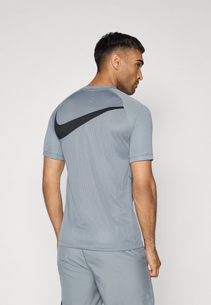 Grå Nike treningsskjorte med korte ermer, med et pustende tekstur og en svart logo aksent over ryggen.